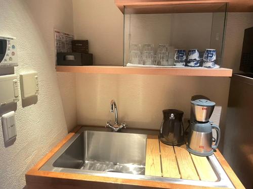a kitchen counter with a sink and a coffee maker at 京都　水凪庵　Kyoto Mizunagian in Giommachi