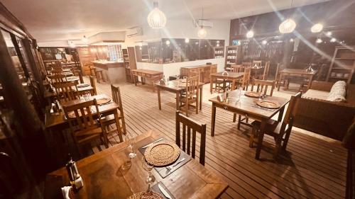 an empty restaurant with wooden tables and chairs at Ilha de Toque Toque Eco Hotel in São Sebastião