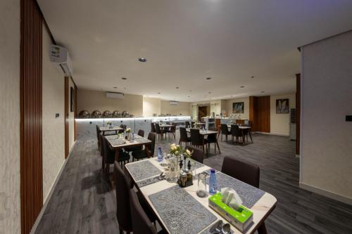 فندق مشارف أبها سويتس في أبها: غرفة طعام مع طاولات وكراسي في مطعم