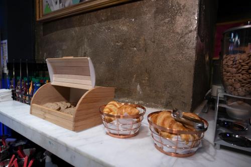 two baskets of bread and a box on a counter at Hotel Forty One in Bucharest