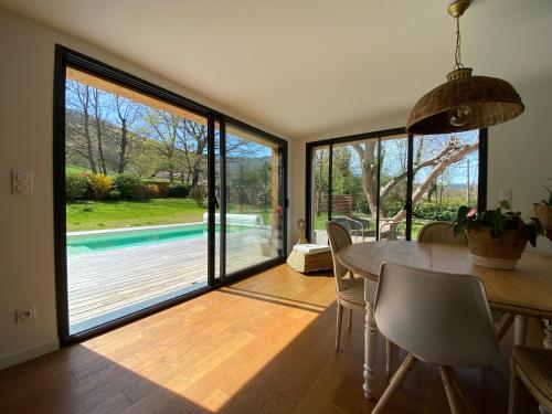 - une salle à manger avec une table et une vue sur la piscine dans l'établissement Villa avec piscine 3 chambres, à Foix
