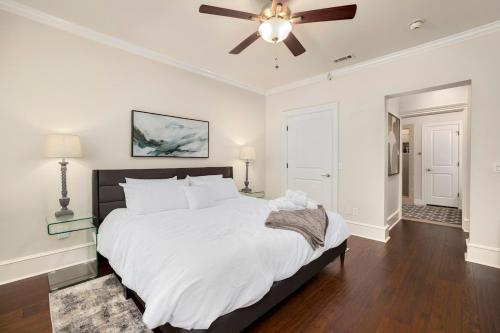 a bedroom with a large bed with a ceiling fan at The Metro - DTWN Fay Condo - 2 Blocks to Dickson St in Fayetteville