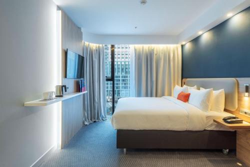 a hotel room with a bed and a large window at Holiday Inn Express - Astana - Turan by IHG in Astana