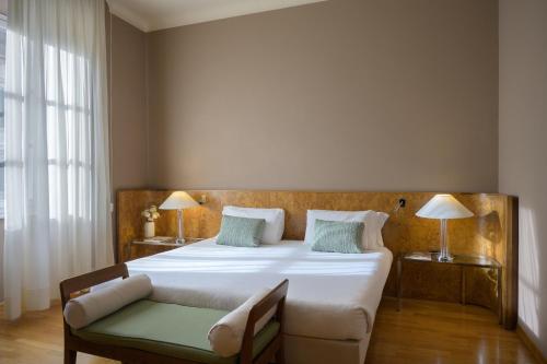a bedroom with a large bed and a chair and a couch at Hotel Ilaria in Lucca