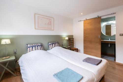 - une chambre avec un grand lit blanc et un lavabo dans l'établissement Isäntä, à La Ferté-Saint-Aubin
