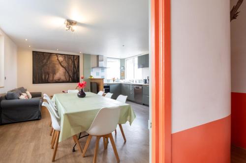 a dining room and living room with a table and chairs at Isäntä in La Ferté-Saint-Aubin