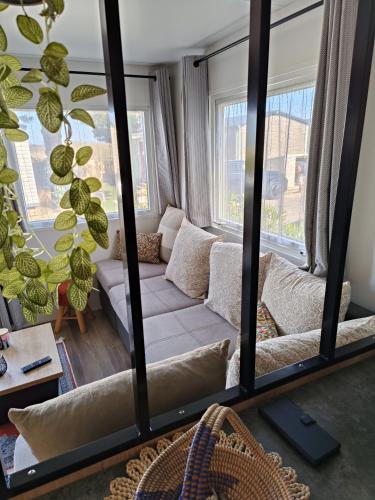 sala de estar con sofá y espejo grande en Mobil home 3 chambres avec vue sur l'étang - 4* en Canet-en-Roussillon