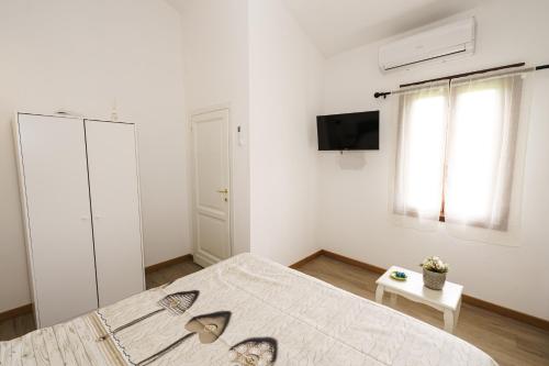 CollestradaにあるIl Fortino di San Francescoの白いベッドルーム(ベッド1台、テレビ付)