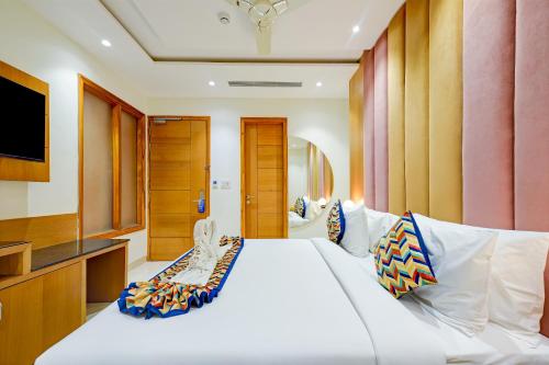 a bedroom with a large white bed and a television at Classio Royale By iO Hotels Near Golden Temple in Amritsar