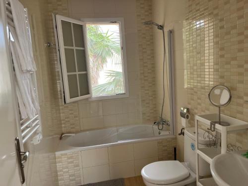 bagno con vasca, servizi igienici e finestra di La Esperanza a Cala Murada