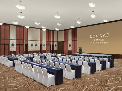 an empty conference room with chairs and a podium at Conrad Urumqi in Ürümqi