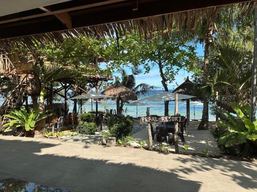 un restaurante con mesas y sombrillas en la playa en Pearl Resort Panglao,Dauis Bikini Beach, en Dauis