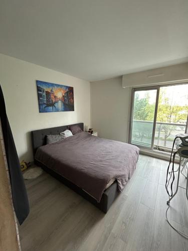 1 dormitorio con cama y ventana grande en Appartement spacieux , proche JO Paris en Saint-Maurice