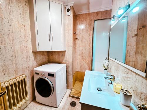 La salle de bains est pourvue d'un lave-linge et d'un lavabo. dans l'établissement Apartamento Samil Primera Línea de Playa 3A, à Vigo