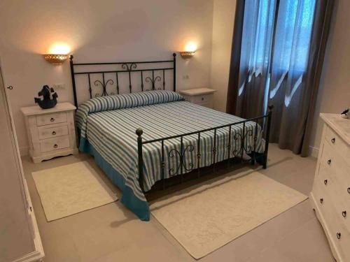 a bedroom with a bed and two night stands at Villa Cristallina Piscina privata, Wi-Fi & Netflix in Stintino