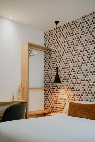 a bedroom with a white bed and a wall with a pattern at Rincon 13 - Mares in Torre del Mar