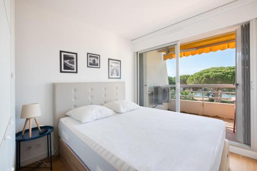 une chambre avec un lit blanc et une fenêtre dans l'établissement AS24001 - P2 dans Résidence sur la plage - vue chenal - parking privé et wifi, au Grau-du-Roi