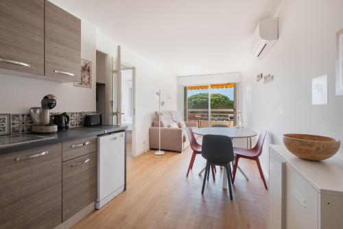 une cuisine et une salle à manger avec une table et des chaises dans l'établissement AS24001 - P2 dans Résidence sur la plage - vue chenal - parking privé et wifi, au Grau-du-Roi