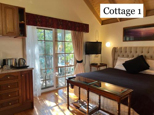 ein Schlafzimmer mit einem Bett mit einem Couchtisch aus Glas in der Unterkunft Olinda Country Cottages in Olinda
