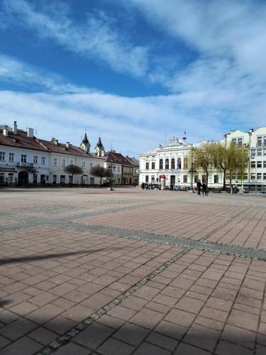 a city square with white buildings and a blue sky at Pokoje Dom Turysty Sanok 24h in Sanok