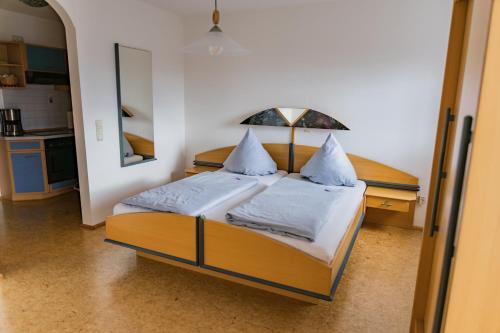 a bedroom with a bed with white sheets and pillows at Ferienhof Hofer in Absberg