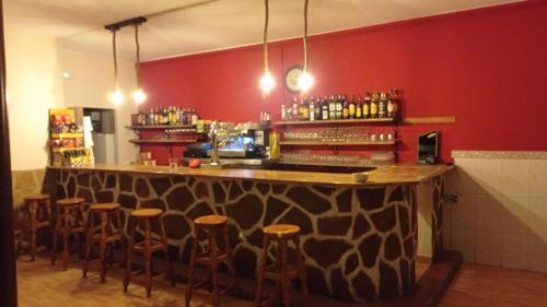 um bar com bancos num quarto com paredes vermelhas em LA POSADA DEL HORNO em Valdecuenca
