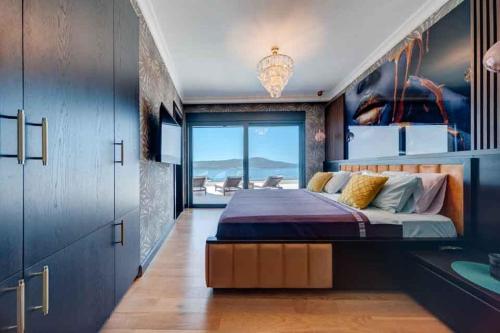 een slaapkamer met een groot bed en een groot raam bij MonteLux Mansion in Tivat
