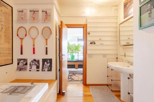 a bathroom with tennis rackets on the wall at Palladio 20 Loft and Terrace in Verona