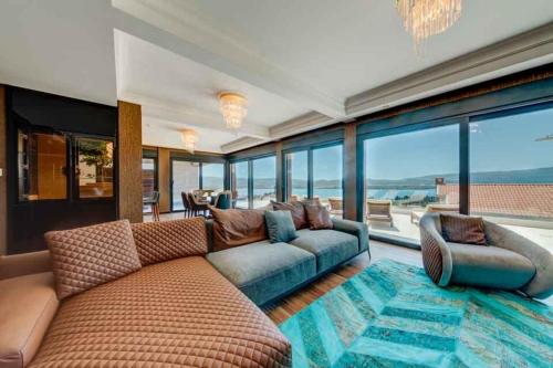 a living room with a couch and a large window at MonteLux Mansion in Tivat