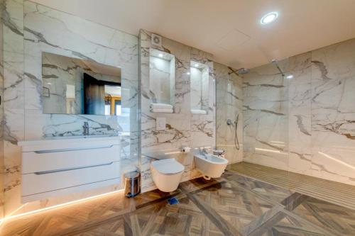 uma casa de banho com um lavatório, um WC e uma banheira em MonteLux Mansion em Tivat