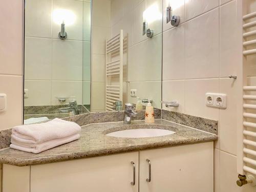 ein Bad mit einem Waschbecken und einem Spiegel in der Unterkunft Residenz Bleichröder - Ferienwohnung 14 in Heringsdorf