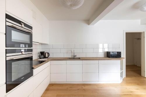 コペンハーゲンにあるStylish Apartments in CPH Cityの白いキャビネットとシンクのあるキッチン