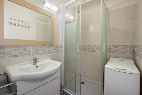 une salle de bain avec un lavabo et une douche dans l'établissement AS23988-Studio cabine, dans une Résidence directe sur Plage, au Grau-du-Roi
