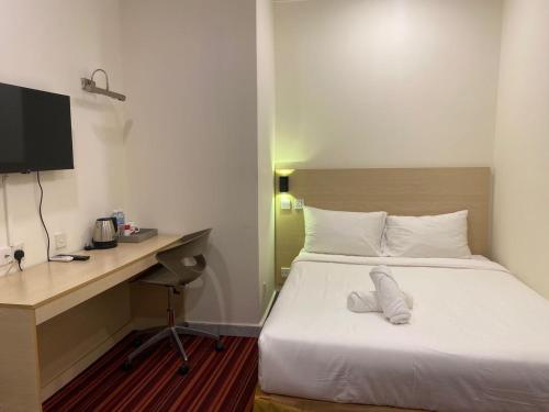 a bedroom with a bed and a desk with a computer at hotel bintang in Kuala Lumpur