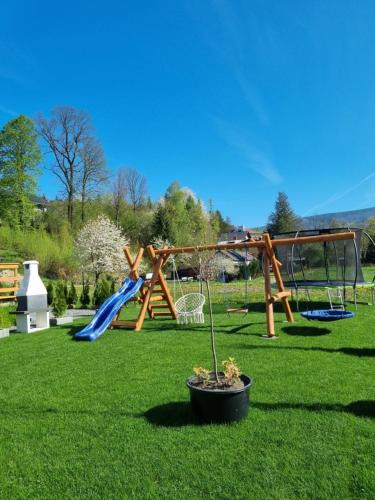 a park with a playground with a slide and swings at Domki U Uli in Wisła