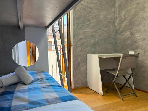 1 dormitorio con cama, espejo y escritorio en Jacuzzi mountain view appartment, en Cassina Valsassina