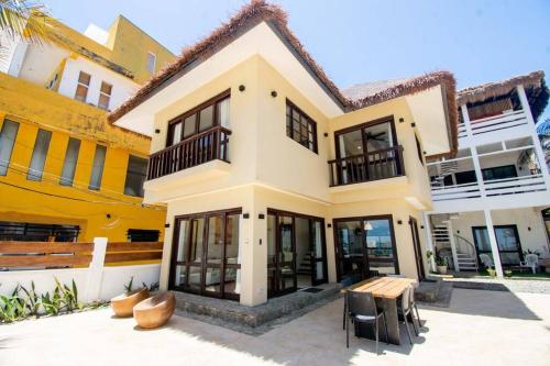 uma casa com uma mesa em frente em Hey Jude Bulabog Beachfront Residence em Boracay