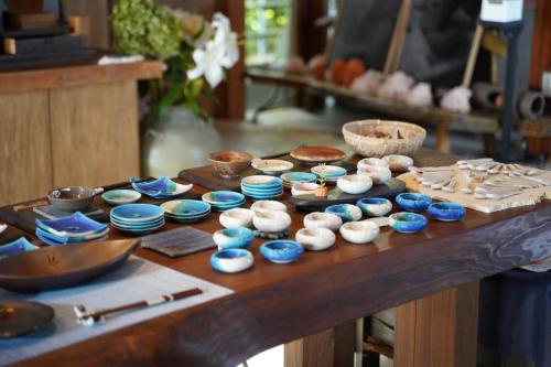 a table with blue and white bowls on it at ホテルコンドミニアム土花土花 in Onna