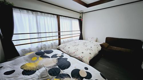 a bedroom with a bed and a couch and a window at Kyoto - Apartment - Vacation STAY 98413v in Kyoto