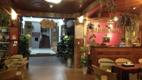 a dining room with tables and chairs and plants at Bình Minh hotel in Mai Chau