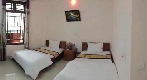 um quarto com duas camas e uma janela em Bình Minh hotel em Mai Châu