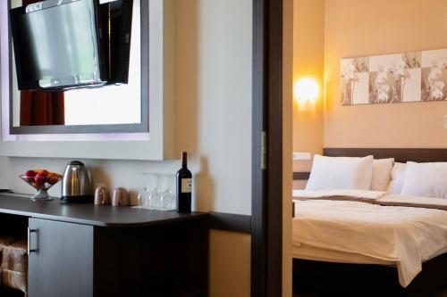 a bedroom with a bed and a bottle of wine at Hotel La Riva in Siófok