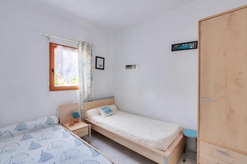 a bedroom with two beds and a window at La maison bleue - Erquy - Piscine couverte in Erquy