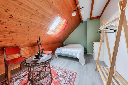 een slaapkamer met een bed en een tafel in een kamer bij Maison avec jardin pour 6 entre golf et plage in Saint-Gildas-de-Rhuys