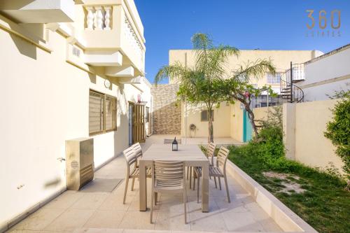 a patio with a table and chairs in a building at Stunning 4BR Villa with private terrace in Balzan by 360 Estates in Balzan