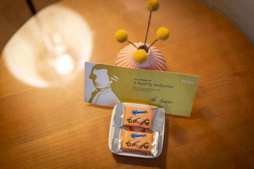 a table with a box of complimentary medicine and a cupcake at Boutique Hotel Das Tigra in Vienna