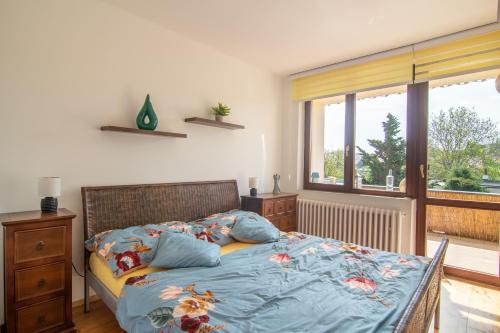 een slaapkamer met een bed met blauwe lakens en een raam bij Apartmán U nás doma in Břeclav