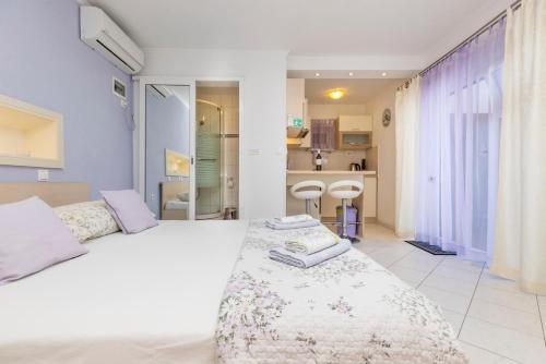 - une chambre avec un lit blanc et des serviettes dans l'établissement Wonderful House Sandra, à Mali Lošinj