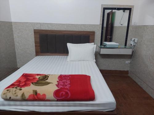 um quarto com uma cama com um cobertor vermelho e um espelho em Nhà nghỉ sao mai 2 em Hanói