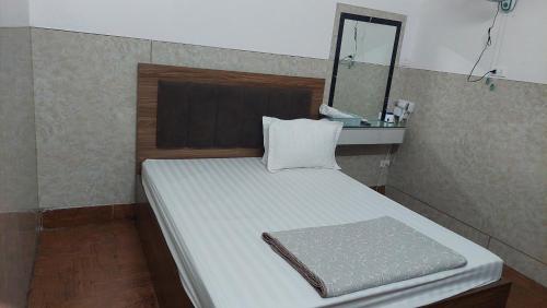 um pequeno quarto com uma cama e um espelho em Nhà nghỉ sao mai 2 em Hanói